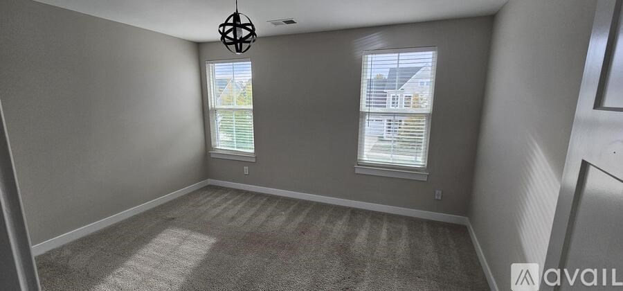 A room with two windows and a carpeted floor.