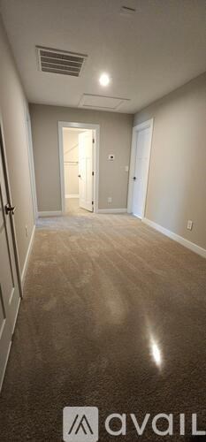 A room with a brown floor and white walls.
