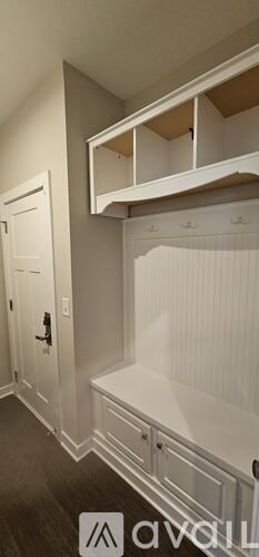 A white wall with a shelf and a door.