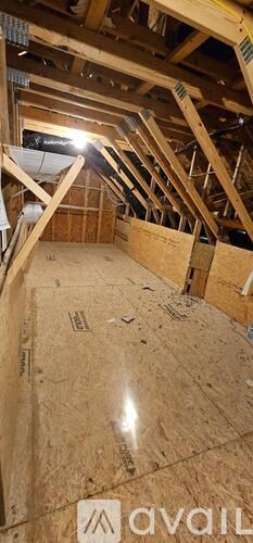 A room under construction with wooden beams and insulation.