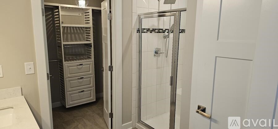 A bathroom with a walk in shower and a large closet.