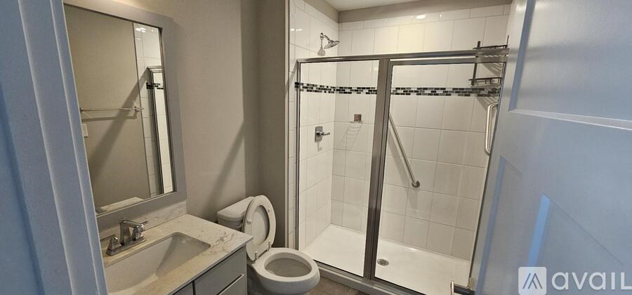 A bathroom with a toilet, sink, and walk-in shower.