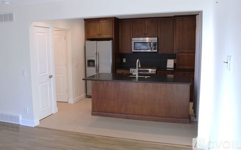 A kitchen with wooden cabinets and a black countertop.