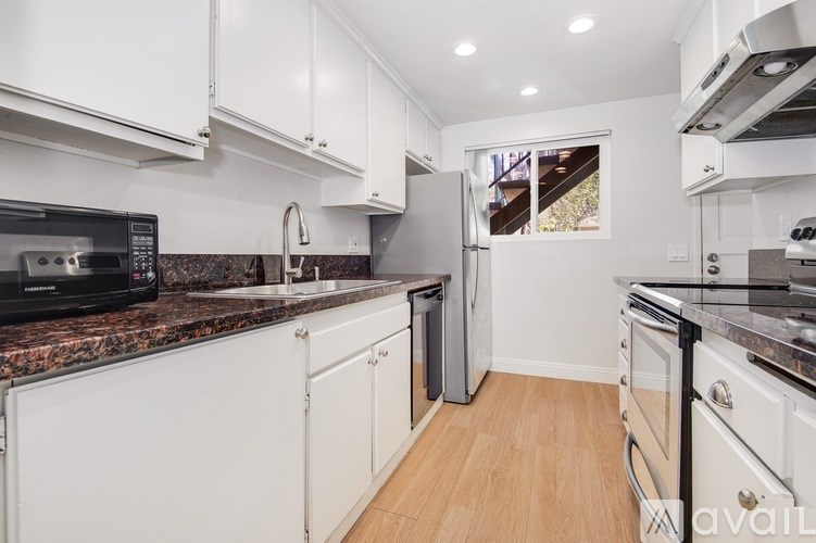 A kitchen with white cabinets and a granite countertop.