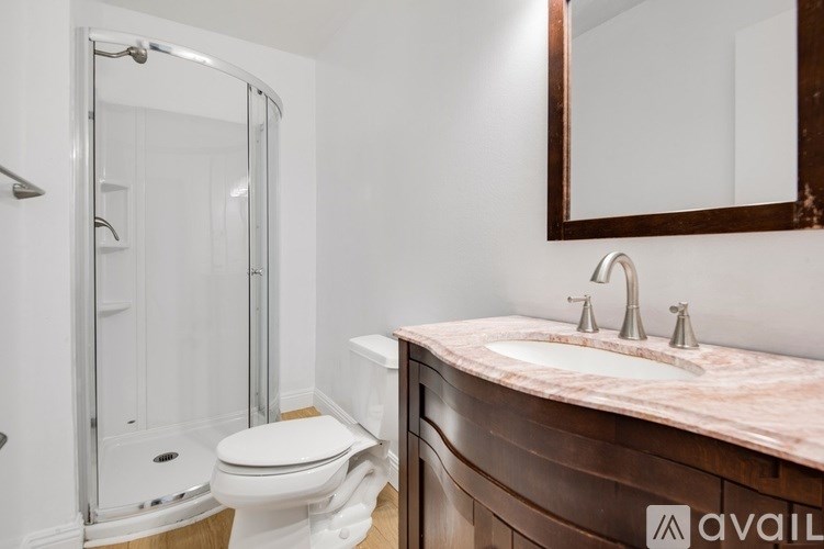 A bathroom with a toilet, sink, and shower.