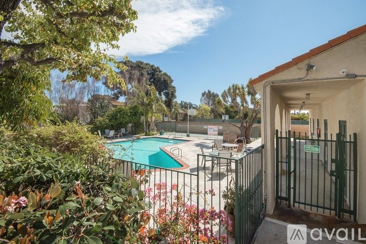 A pool surrounded by a fence and trees.