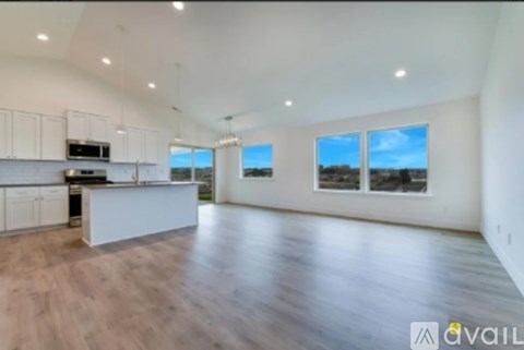 A spacious living room with wooden floors and large windows.