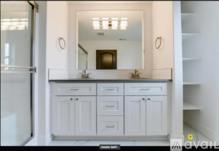 A white bathroom with a mirror and a sink.