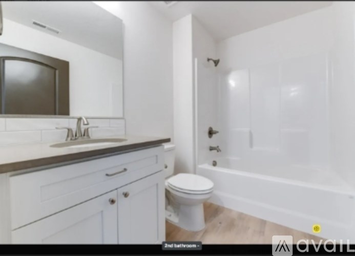 A bathroom with a toilet, sink, and bathtub.