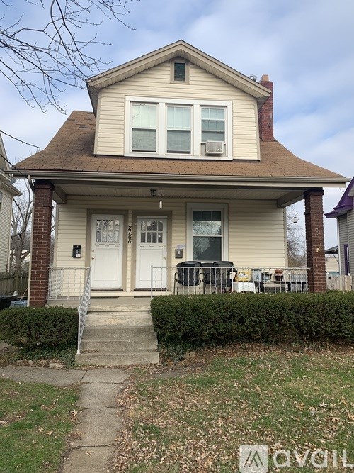 A two-story house with a white door and windows.
