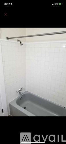 A white tiled bathroom with a bathtub and shower.