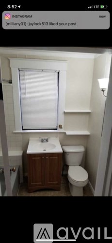 A small bathroom with a toilet, sink, and window.