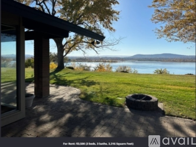 A patio with a view of a lake and mountains.