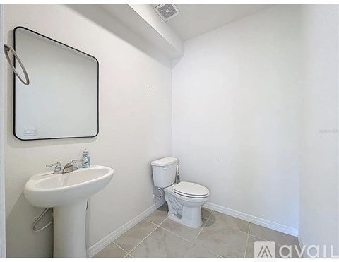 A white toilet sits next to a sink in a small bathroom.
