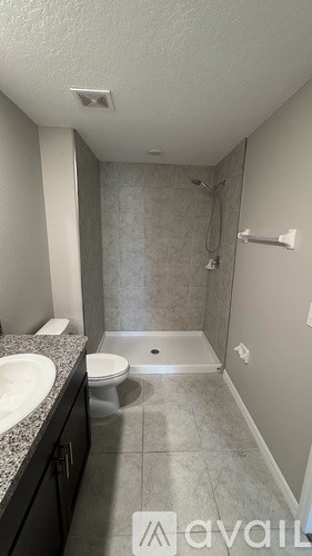 A bathroom with a toilet, sink, and shower.