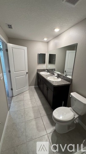 A bathroom with a toilet, sink, and mirror.