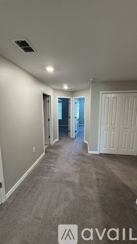 A long hallway with a carpeted floor and white walls.