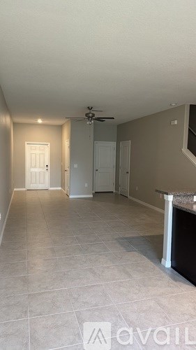 A spacious room with a ceiling fan and a counter.