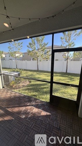 A patio with a view of a backyard and a fence.