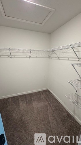 Empty room with a carpeted floor and metal shelving.