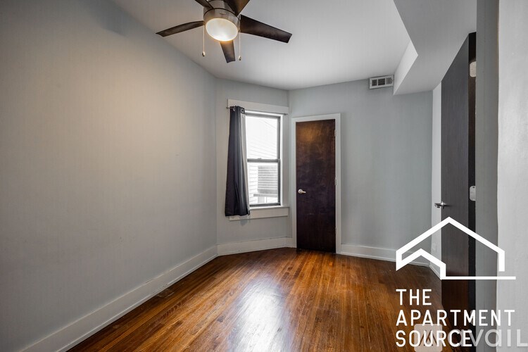 A room with a ceiling fan and wooden floors.