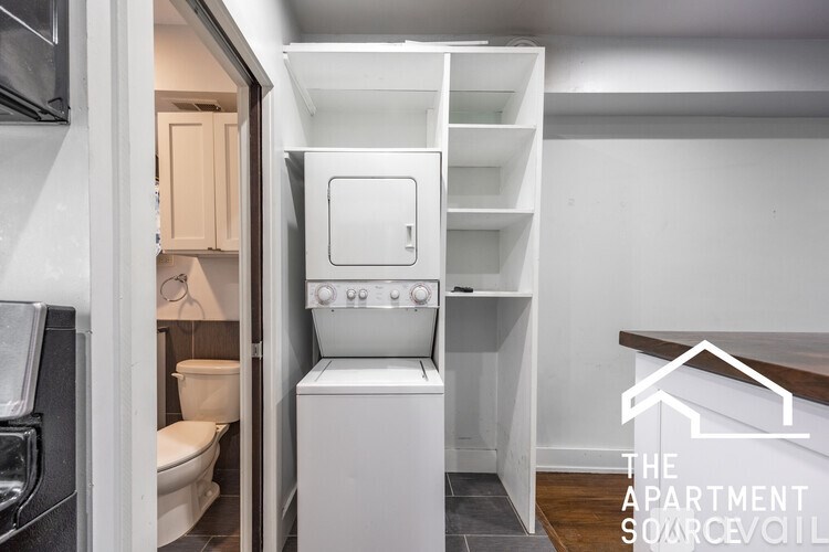 A small, white, compact kitchen with a sink and a refrigerator.