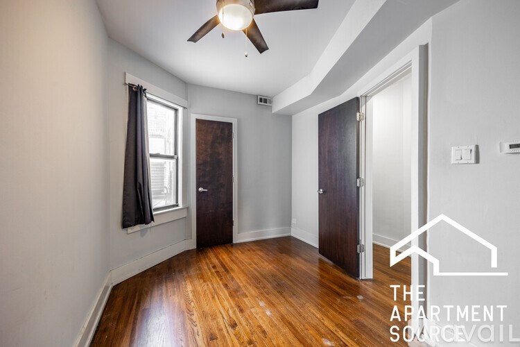A room with wooden floors and a ceiling fan.