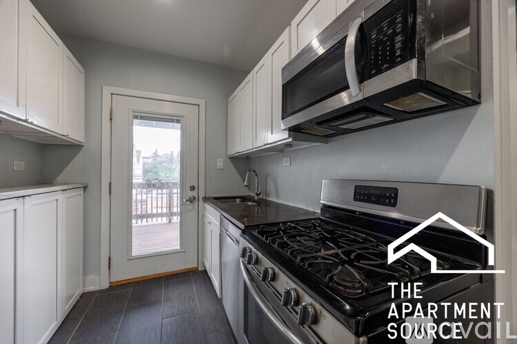 A kitchen with a stove, microwave, and oven.