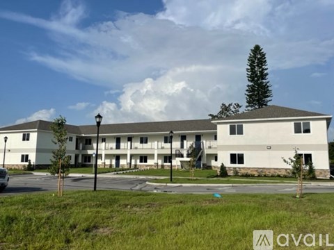 A large white building with a parking lot in front.