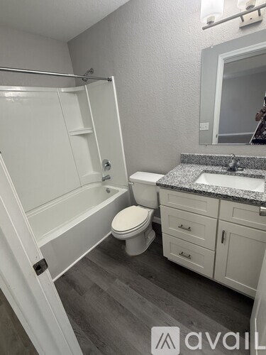 A bathroom with a toilet, sink, and bathtub.