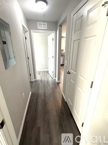 A hallway with white doors and a wooden floor.