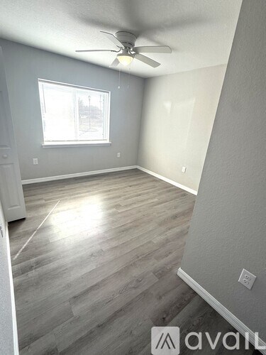 A room with a ceiling fan and a window.