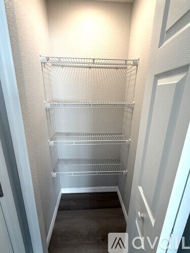 A white pantry with shelves and a door.