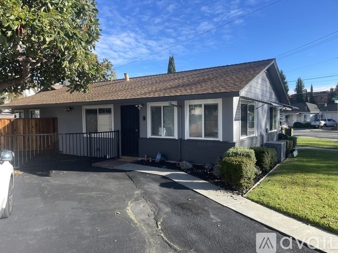 A house with a grey roof and a white car parked in front.