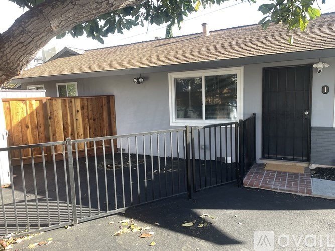 A house with a black door and a grey fence.
