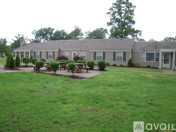 A house with a lawn and a picnic table in front.