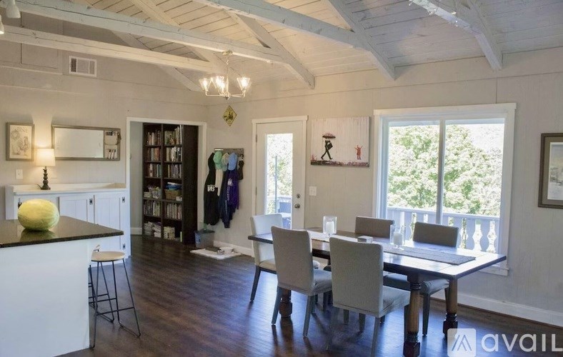 A kitchen with a dining table and chairs.