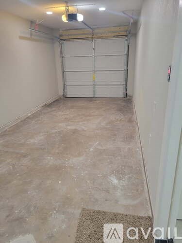 A garage with a white door and a mat on the floor.