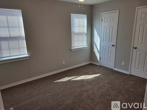 A room with two windows and a carpeted floor.