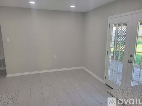 A room with a white door and a tiled floor.