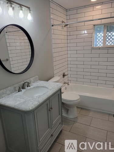A bathroom with a white sink, toilet, and bathtub.