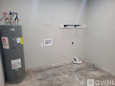 A room with a grey floor and a grey wall with a grey tank on the left.