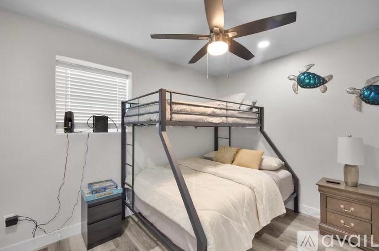 A bedroom with a bunk bed and a ceiling fan.