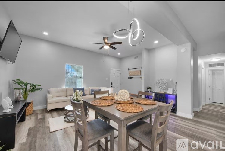 A modern dining room with a wooden table and chairs.