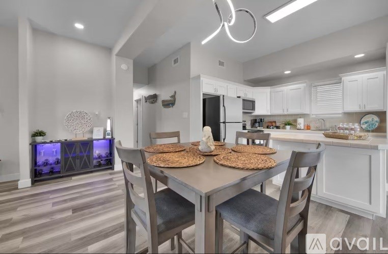 A modern kitchen with a dining table set for two.