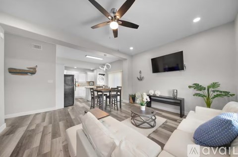 A modern living room with a white couch and a wooden floor.