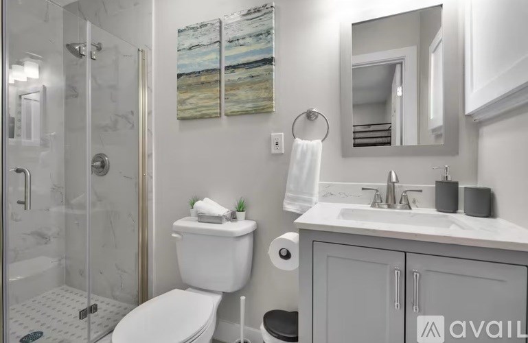 A bathroom with a toilet, sink, and shower.