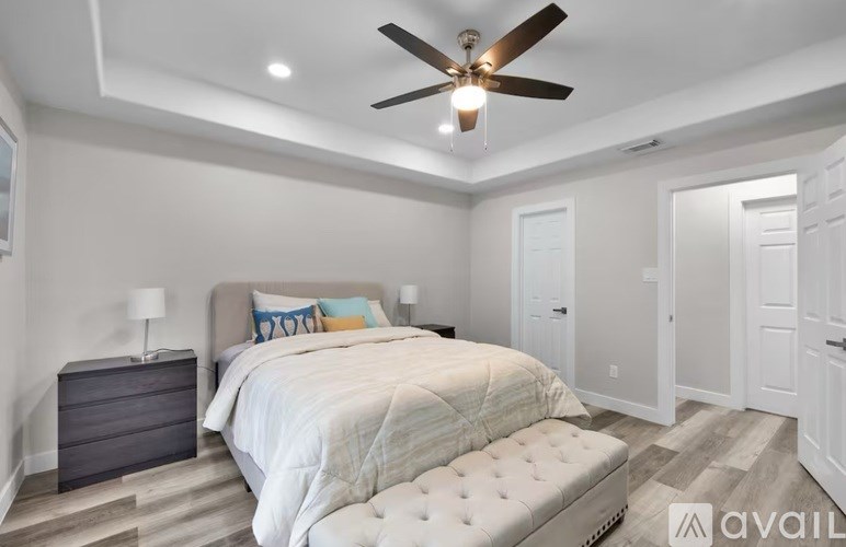 A bedroom with a large bed and a ceiling fan.