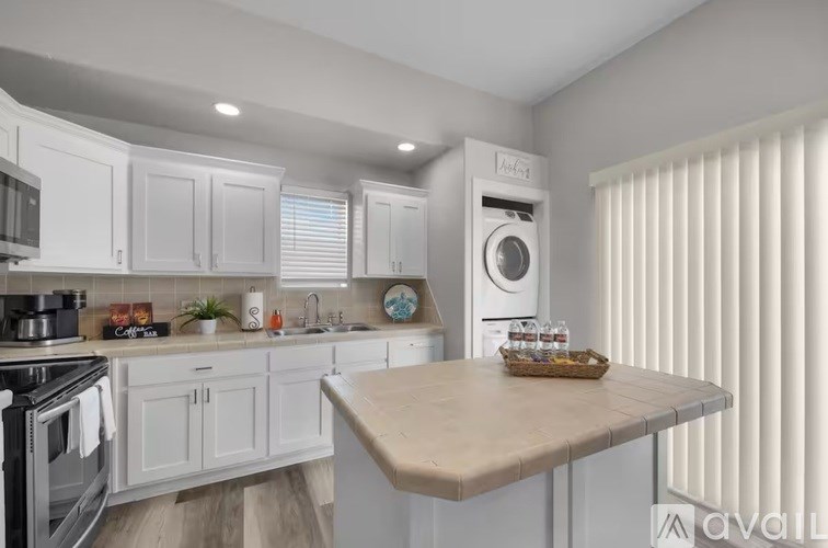 A kitchen with white cabinets and a wooden table.