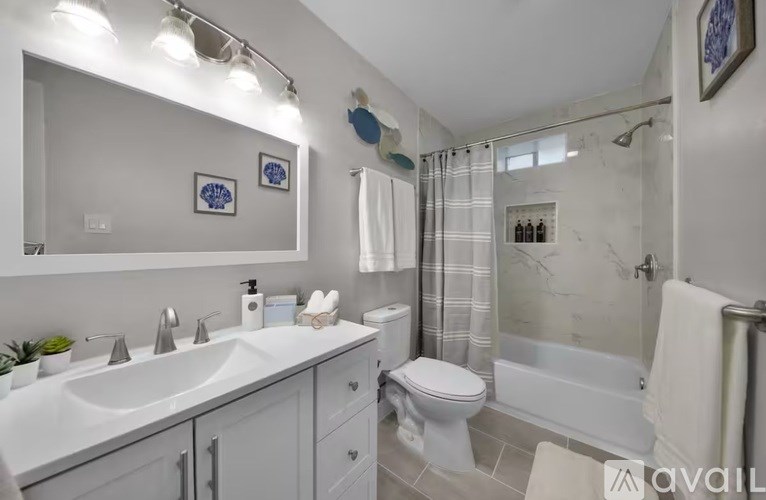 A bathroom with a white sink, toilet, and bathtub.
